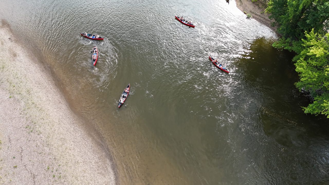A group of Roscoe Village Canoe Livery canoes spread across the river on a group trip