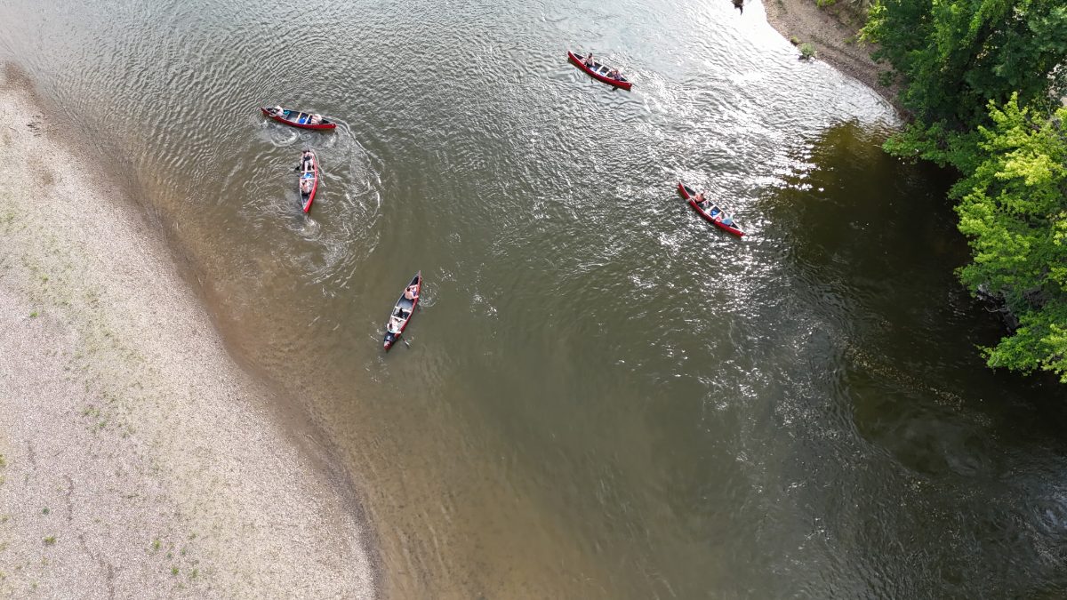 A group of canoes spread across the river on a Roscoe Village Canoe Livery trip
